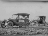 Print of two old cars with people (Model T era).